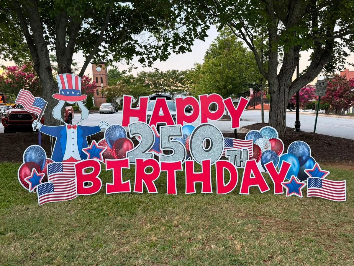Red, white and blue Happy 250th Birthday display with Uncle Sam and flags